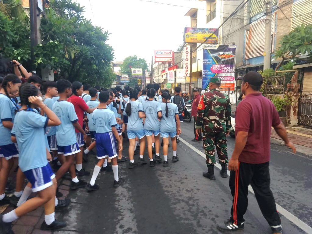 Dukung Kelancaran Perayaan Sekolah – Babinsa Pantau Rute Jalan Santai SMPN 7 Denpasar
